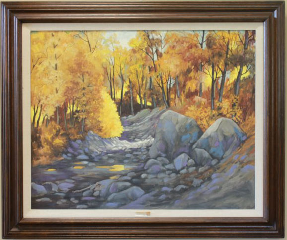 "Sun Glow" by Joyce Pitts. Oil painting depicting fall landscape scene. Large stony riverbed lined with trees with yellow and orange leaves.